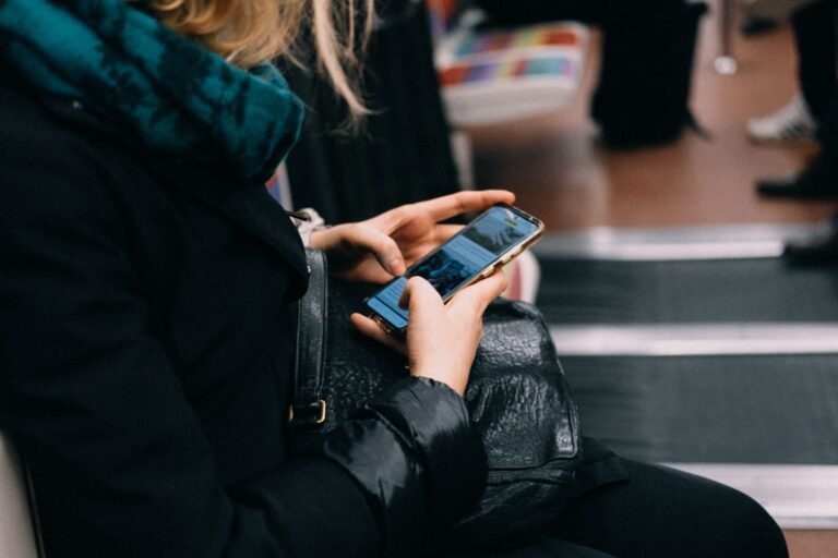 A woman uses her smartphone while commuting on public transportation.